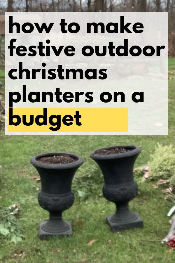 two black planters sitting in the grass with text overlay saying how to make festive outdoor christmas planters on a budget