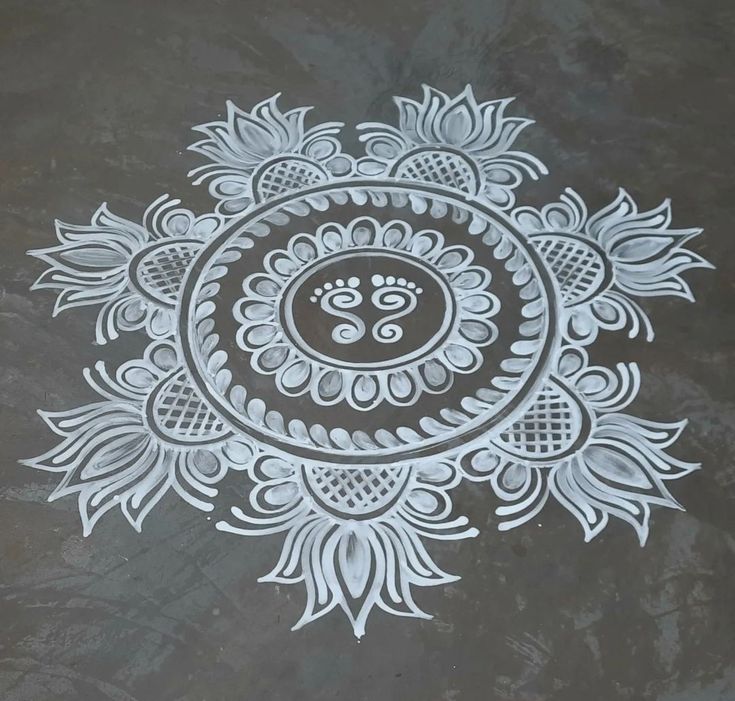 an intricately designed design on the ground in white and grey colors with black background