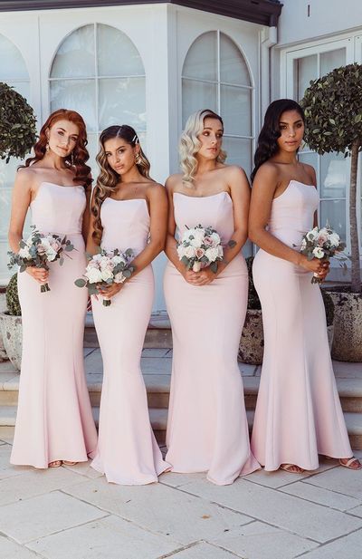 the bridesmaids are all wearing different styles of pink dresses and bouquets in their hair