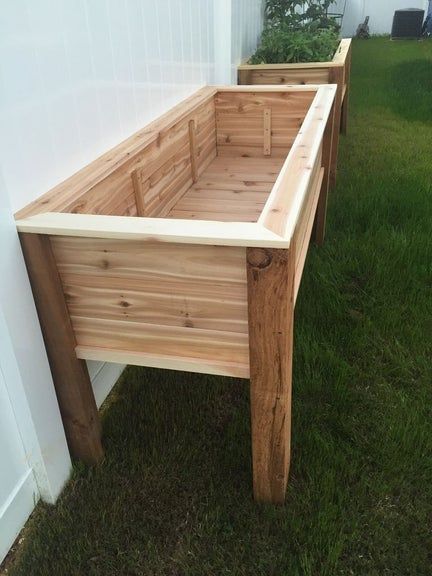 two wooden planters sitting in the grass