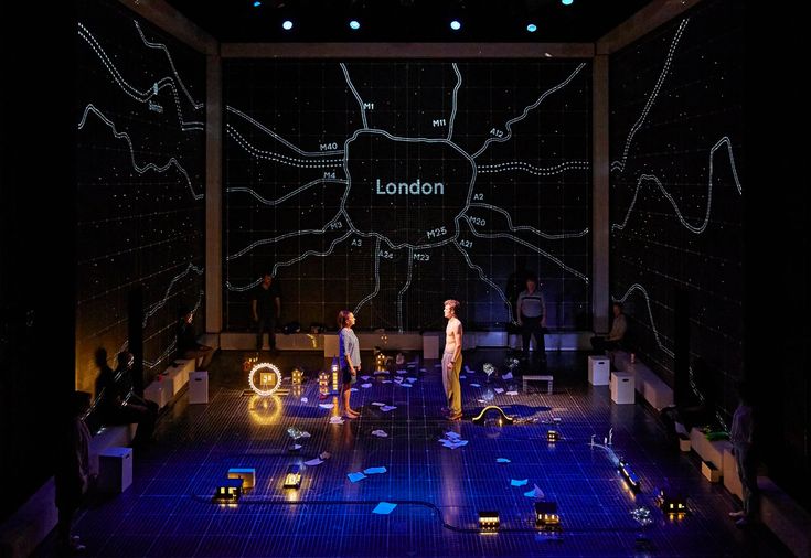 two people standing on a stage in front of a projection screen with the words london written on it