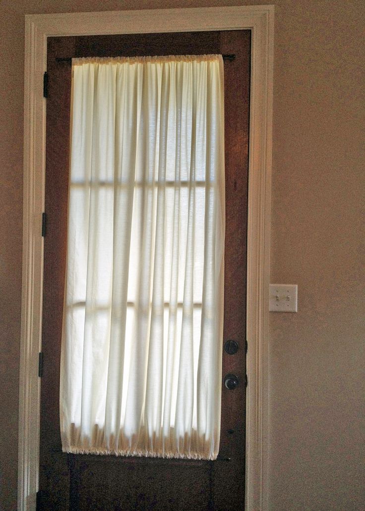 an open door with a curtain hanging on it's side in front of a window