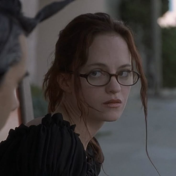 a woman with glasses looking at another person