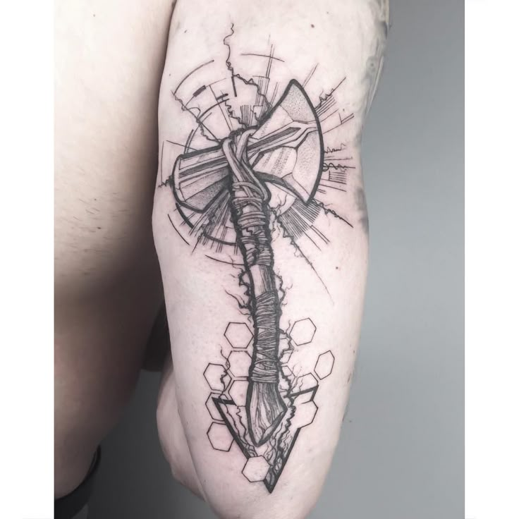 a man's arm with a cross tattoo on it and an arrow in the middle