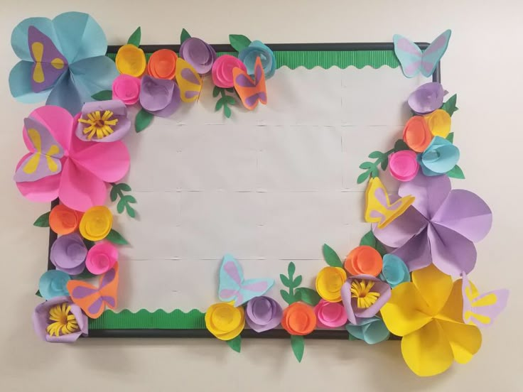 paper flowers and butterflies on a white board