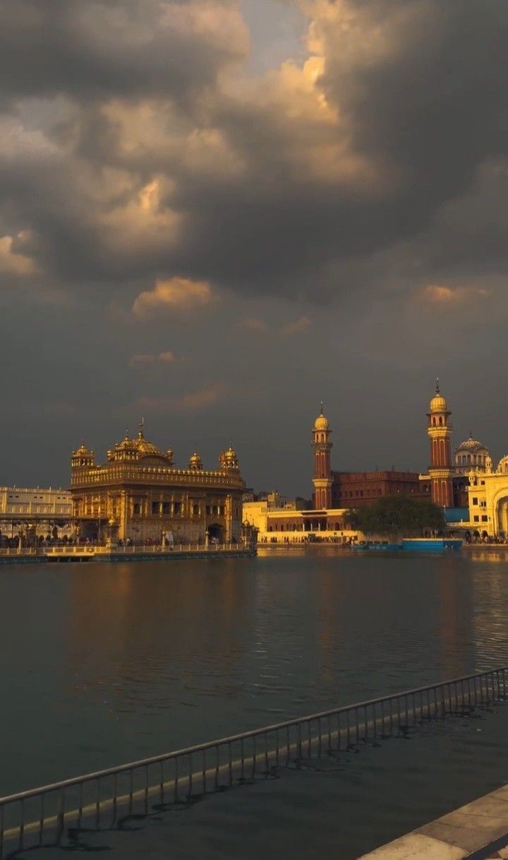 a large body of water with buildings on both sides and cloudy skies in the background