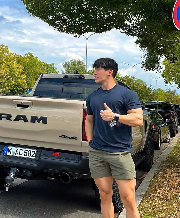 a man standing next to a truck giving the thumbs up