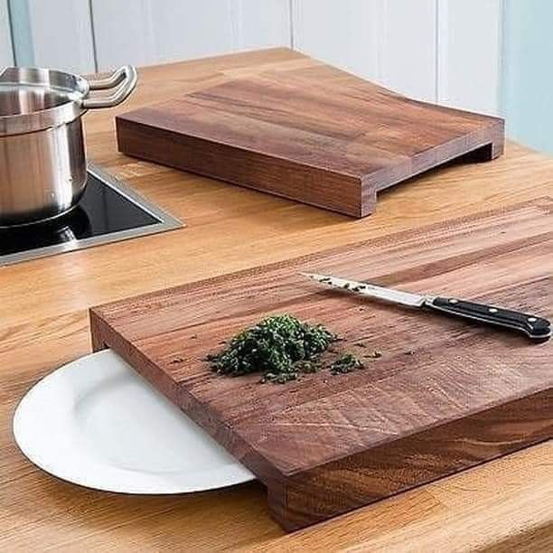 a wooden cutting board sitting on top of a table next to a knife and bowl