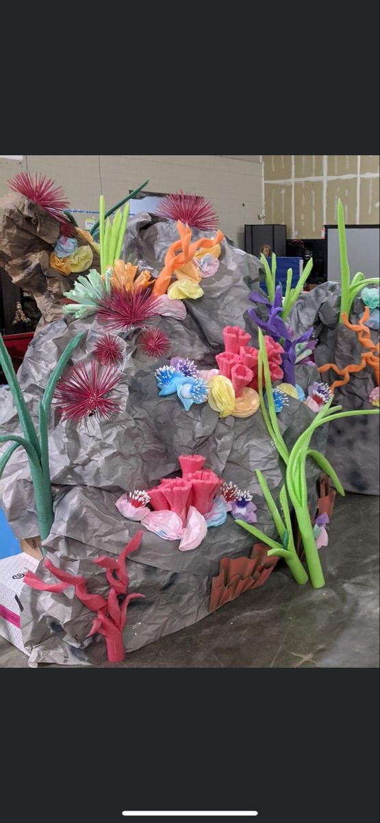 an art project made out of rocks and paper flowers