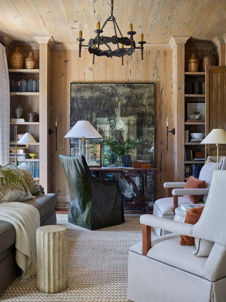 a living room filled with furniture and a chandelier hanging from the ceiling in front of a painting