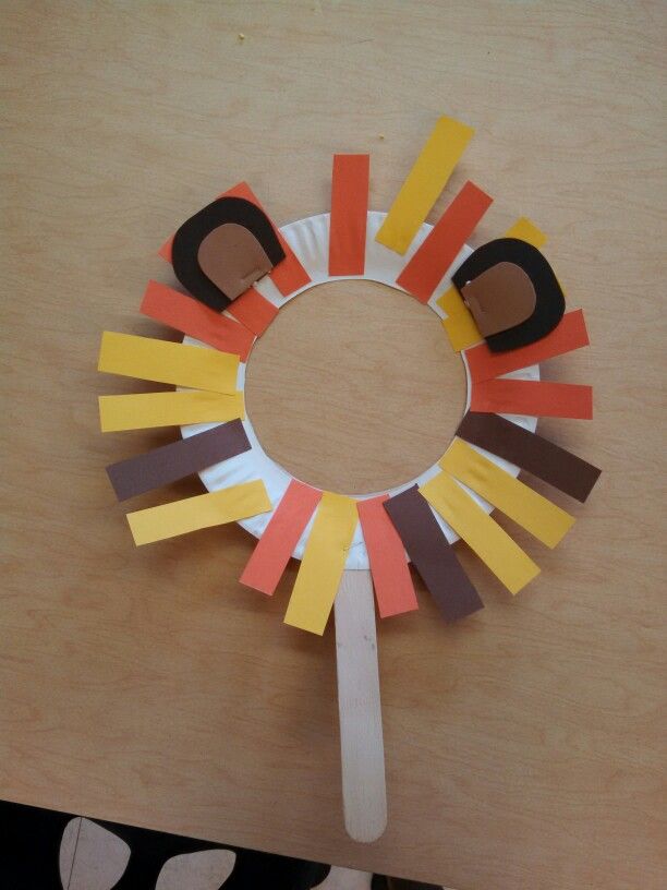 a paper circle made to look like an animal's head with strips of construction paper on it