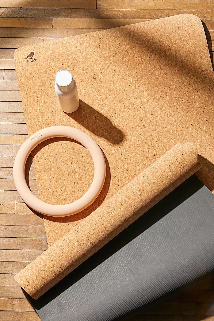 an overhead view of a cork board with a ring and other items on it next to a yoga mat