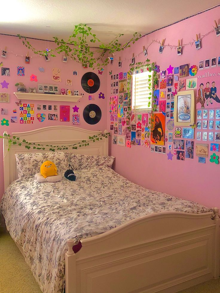 a bed in a room with pink walls and pictures on the wall above it,