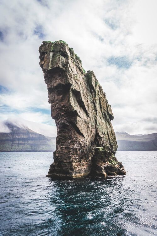 a large rock sticking out of the water