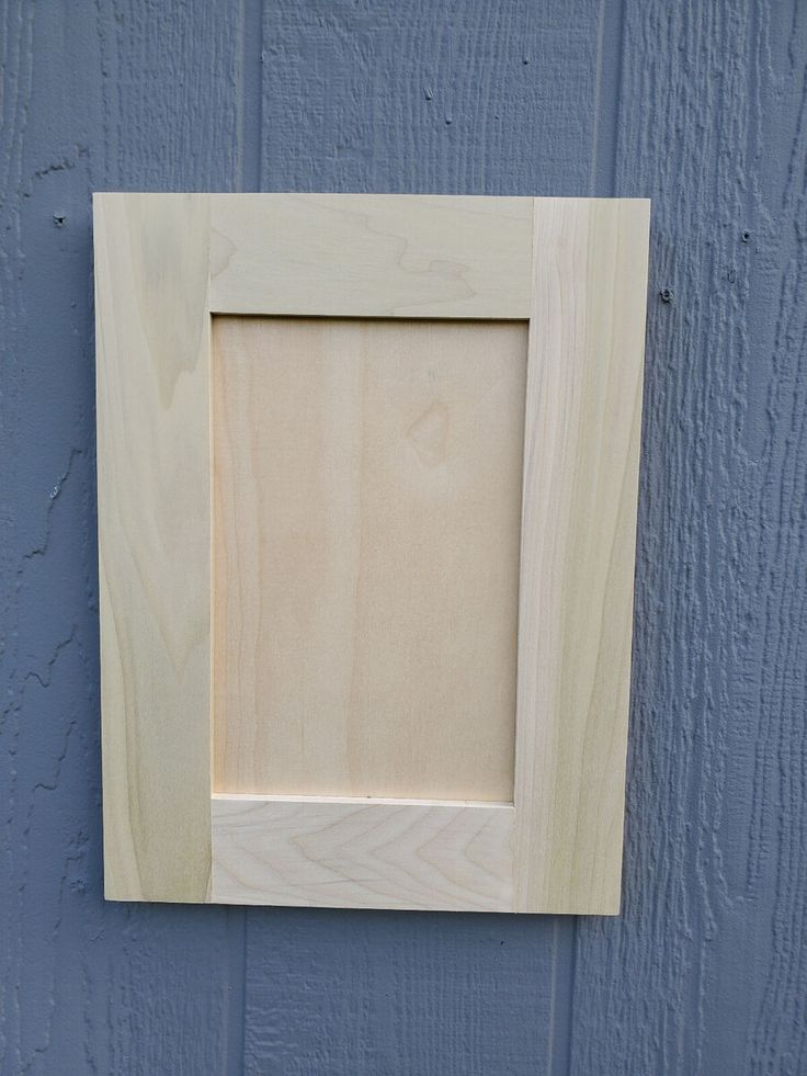 a wooden frame mounted to the side of a blue painted wall with wood grains