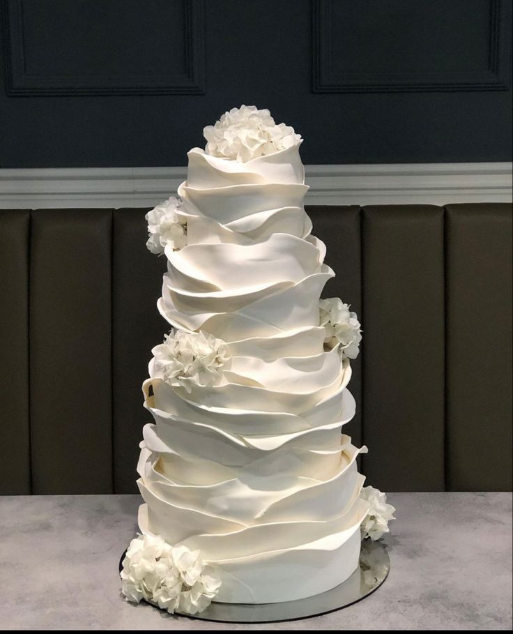 a large white wedding cake with flowers on top