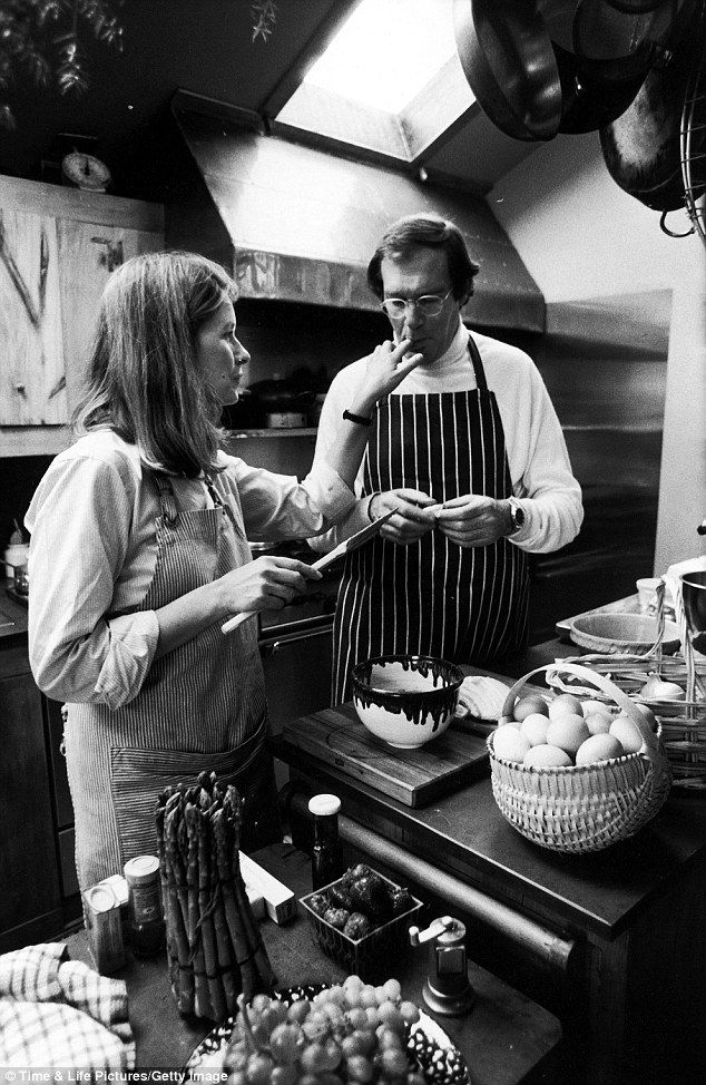 two people standing in a kitchen preparing food