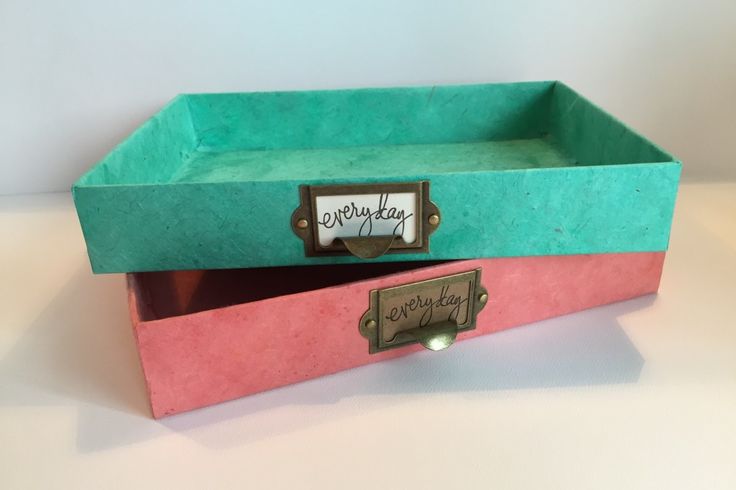 two pink and green boxes with writing on the top one has a name tag in it