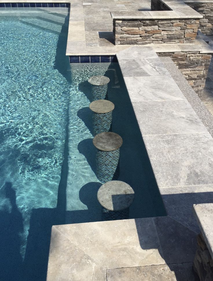 an empty swimming pool surrounded by stone steps