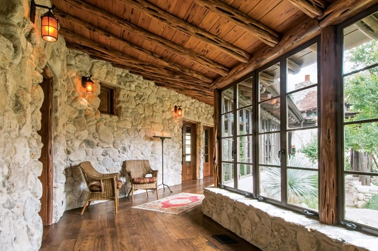 the inside of a house with stone walls and wood floors