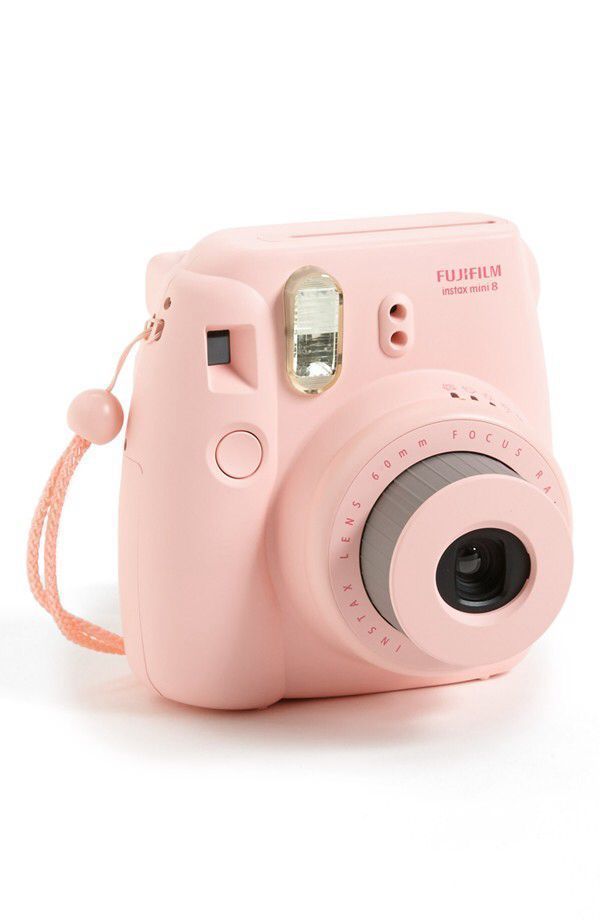 a pink camera sitting on top of a white table