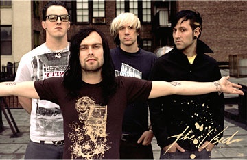 a group of men standing next to each other in front of a brick building with their arms stretched out