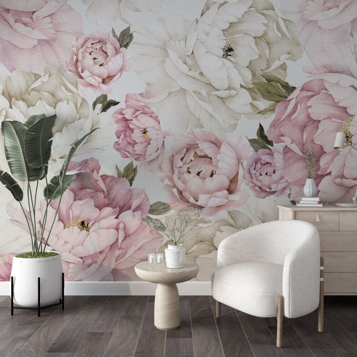 a white chair sitting in front of a wall with pink flowers on it