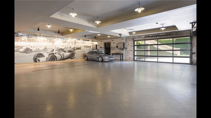 an empty garage with two cars parked in front of a large mural on the wall