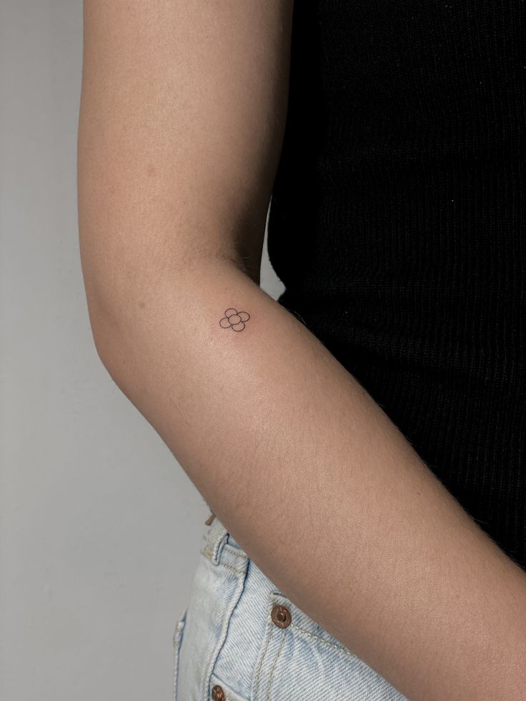 a woman's arm with a small tattoo on the left side of her arm