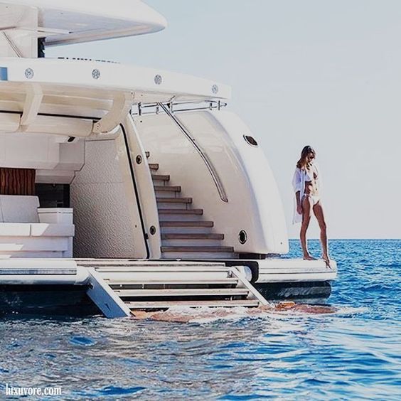 a woman is standing on the deck of a boat in the middle of the ocean