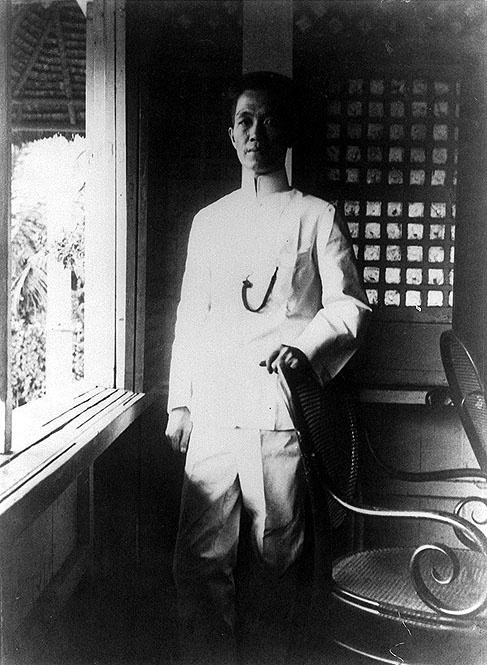 black and white photograph of a man standing in front of a window