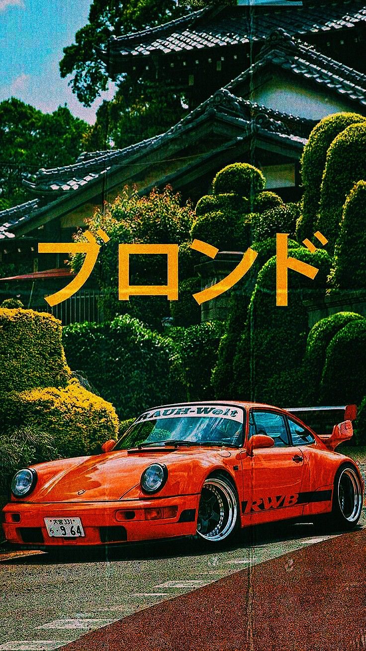 an orange sports car parked in front of a japanese house with the word japan on it