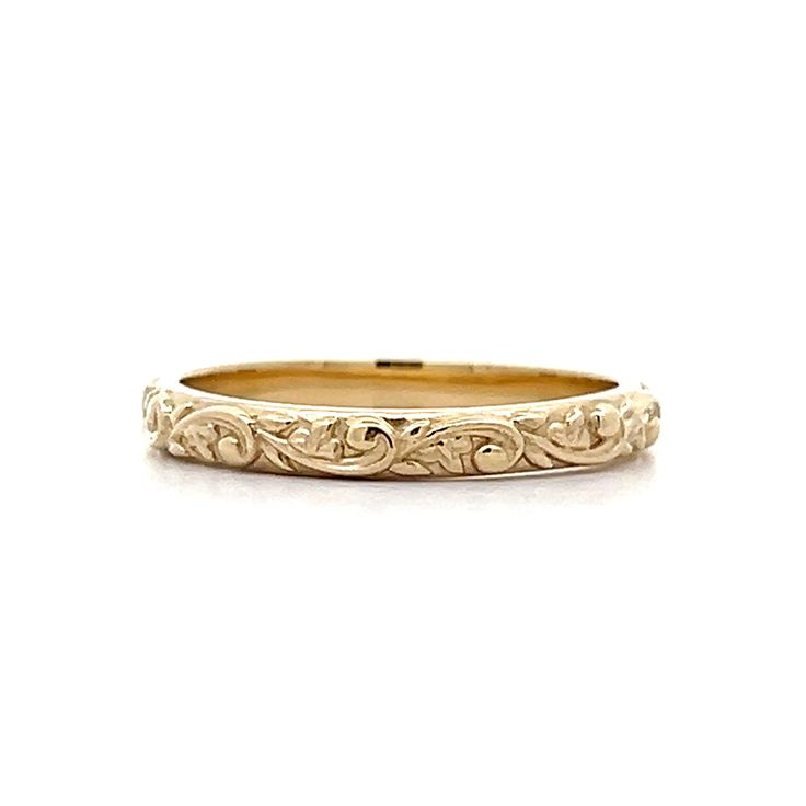 a gold wedding band with an intricate design on the inside and outside, set in 18k yellow gold