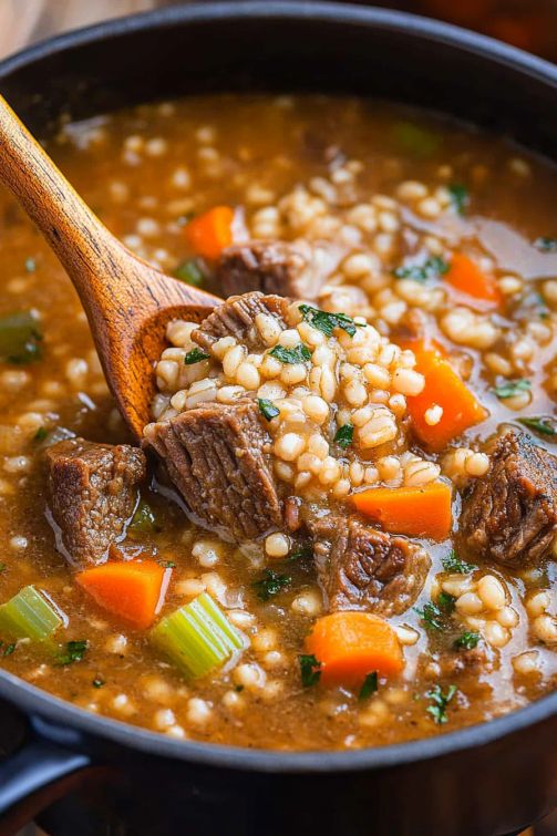 a pot filled with beef and barley soup