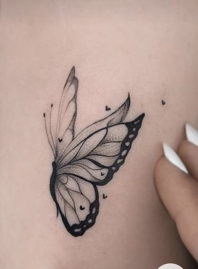 a woman's stomach with a black and white butterfly tattoo on the side of her belly