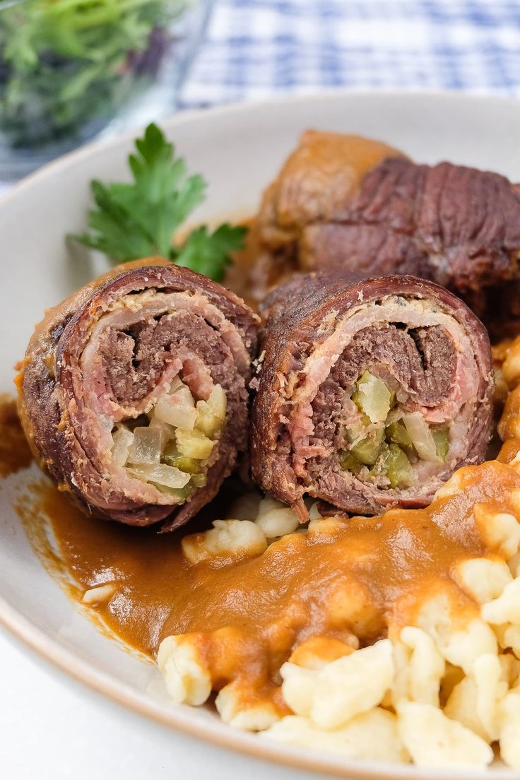 a plate with some meat rolls and macaroni on it