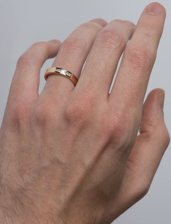 a man's hand with a gold ring on it