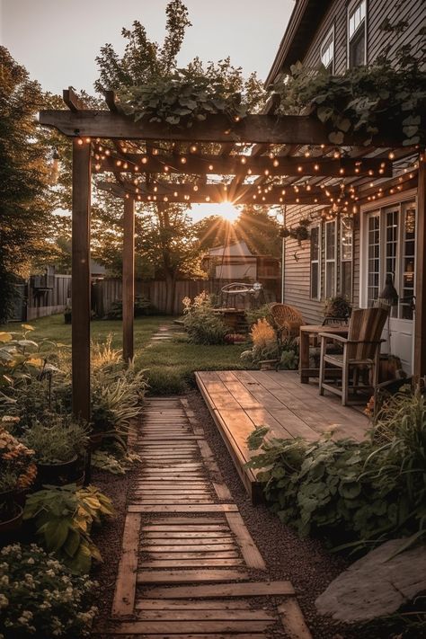 the sun is setting over an outdoor patio with lights strung on it and wooden steps leading to