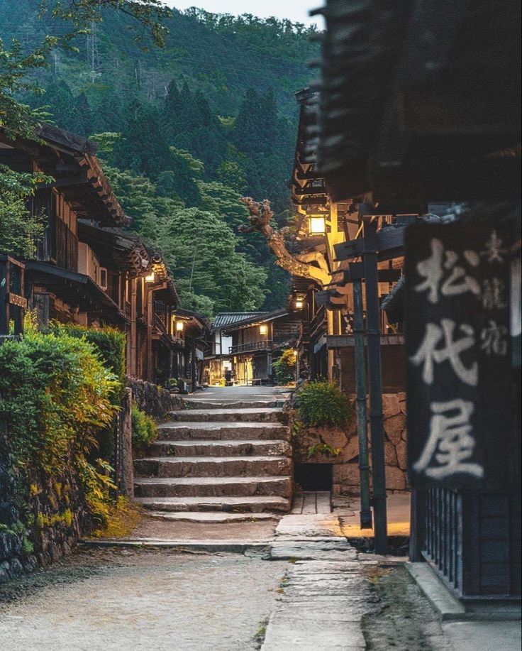 an alley way with steps leading up to some buildings and trees on the side walk