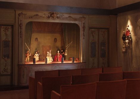 an empty church with wooden pews and decorated stage in the back ground, looking toward the front door