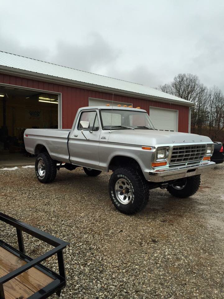 an old pick up truck parked in front of a garage