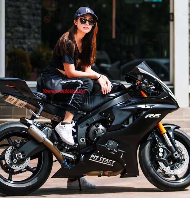 a woman sitting on top of a black motorcycle