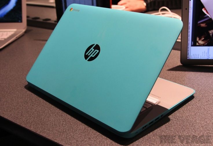 a blue laptop computer sitting on top of a desk next to a lap top computer