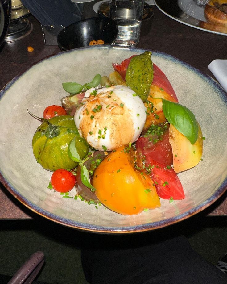 a white bowl filled with lots of different types of food on top of a table