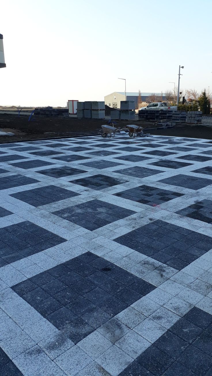 a black and white checkerboard pattern is on the ground in an empty parking lot