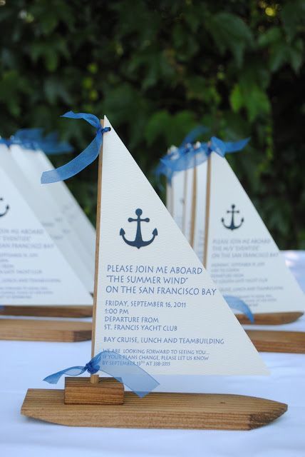 three small sail boats with blue ribbons on them