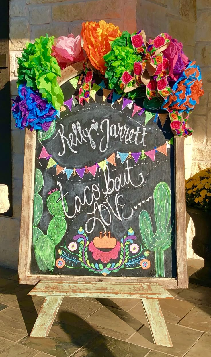 a chalkboard sign decorated with colorful paper flowers