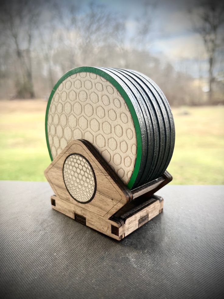 a stack of discs sitting on top of a wooden stand in front of a field