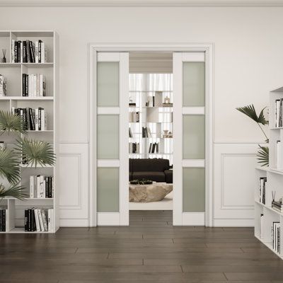 an empty living room with bookshelves and plants