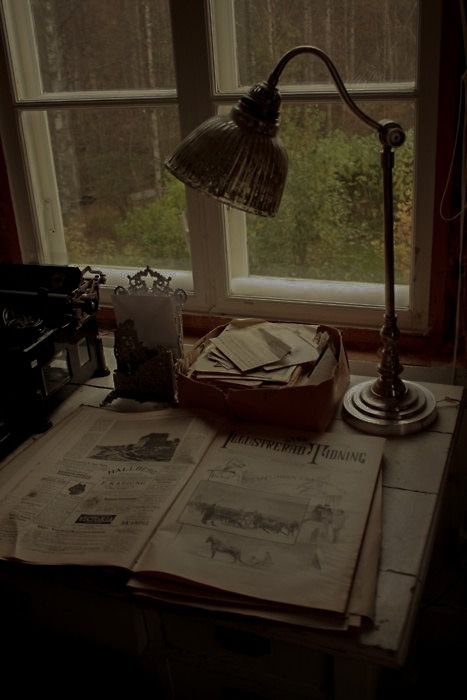 an old fashioned lamp is sitting on top of newspapers